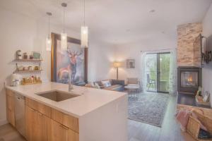 uma cozinha com um lavatório e uma sala de estar em Cozy- Mountain Style - River View apartment - Colorado em Silverthorne