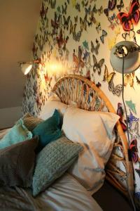 a bedroom with a bed with butterflies on the wall at N°5 Lumen in Flobecq