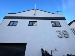 a white building with a sign on it at Stunning New 2 Bed Flat - 6 August House in London