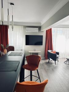 a kitchen and living room with a counter and chairs at Maia Grand Studio Bucharest in Bucharest