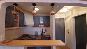 a kitchen with a wooden table and some lights at Valentino Apartment in Castelrotto