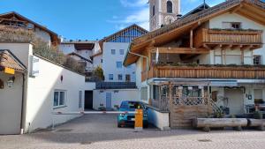 a car parked in a parking lot in front of a building at Valentino Apartment in Castelrotto