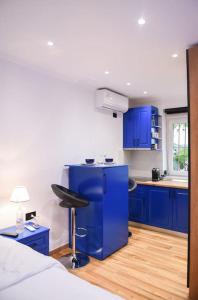 uma cozinha com armários azuis e um banco num quarto em City Center 12 - Tirana Way Apartments em Tirana