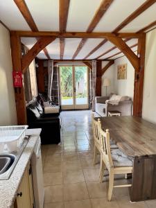 cocina y sala de estar con mesa de madera en Chez Jallot - Lower Gite en Vidaillat