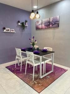 Un comedor con una mesa y sillas sobre una alfombra. en Cameron Lavender Homestay, en Cameron Highlands
