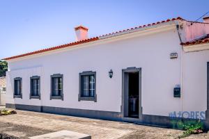 un edificio blanco con ventanas negras y una puerta en Porto Tranquilo, en Porto Martins