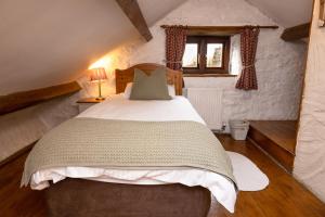 Swallow Cottage في بريدجيند: غرفة نوم بسرير كبير في غرفة