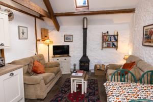 a living room with a couch and a stove at Swallow Cottage in Bridgend