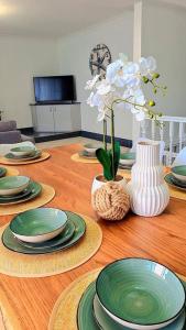 a wooden table with green plates and vases on it at Bennett's Bliss - Ocean View, 5 Bedrooms, 14 Guest in Forster
