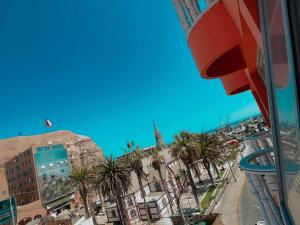 a view of a city with palm trees and a church at Hotel Plaza Colon in Arica