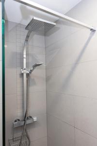 a shower with a shower head in a bathroom at Swallow Cottage in Bridgend