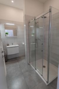 ein Bad mit einer Glasdusche und einem Waschbecken in der Unterkunft Main Square Dream Apartment in Zagreb