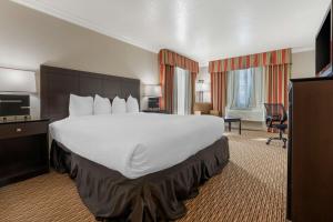 a hotel room with a large bed and a desk at Best Western Colonial Inn in Selma