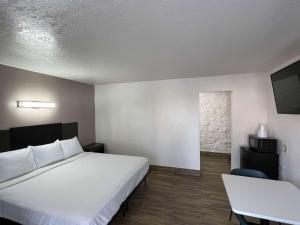a hotel room with a bed and a table and a window at Motel 6-Orange, CA - Anaheim in Anaheim