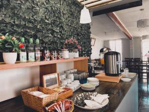 a restaurant with a counter with plates and dishes at Hotel Plaza Colon in Arica