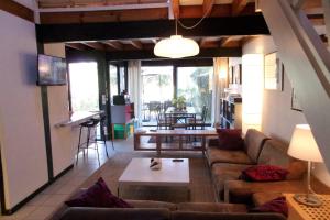 a living room with a couch and a table at Beautiful 67 m duplex with gardengolf view in Moliets-et-Maa