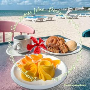 a table with two plates of food and a cup of coffee at Hotel Cocoplum Beach in San Andrés