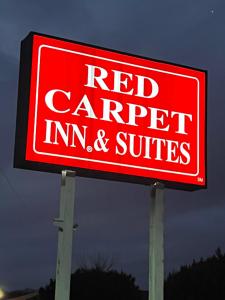 zajazd i apartamenty typu suite z czerwonym dywanem podpisane na słupie w obiekcie Red Carpet Inn & Suites Wrightstown w mieście Wrightstown
