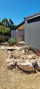 a garden with rocks in front of a house at Wally's Edge 20acre Farm Stay in Rawson