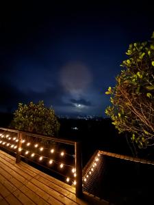une rangée de lumières sur une terrasse la nuit dans l'établissement Giüg Refugio, à Medellín