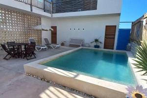 a swimming pool in a patio with a table and chairs at Casa Manuela: Espectacular villa al frente del mar in Sisal