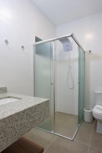 a bathroom with a shower with a sink and a toilet at Pousada Salto Donner in Rio Forcação