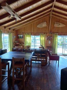 un comedor con una gran mesa de madera y sillas en EKILIBRE Surf Eco Hostal, en Curanipe