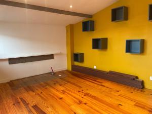een kamer met een gele muur en een houten vloer bij Le cocon tournaisien in Tournai