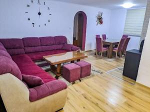 a living room with a purple couch and a table at Vila "Strahinja" Jahorina in Jahorina