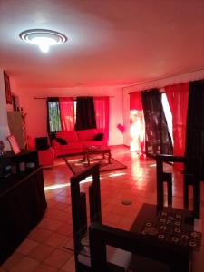 a living room with red curtains and a red couch at Lavish Condo @Carlos Residential in Sosúa