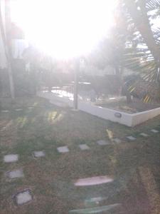 a yard with rocks in the grass with the sun shining at Lavish Condo @Carlos Residential in Sosúa