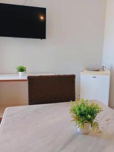 a room with a table with a tv on the wall at Pousada Aruamar in Aracaju