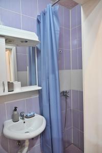 uma casa de banho com um lavatório e uma cortina de chuveiro azul em Apartmani Tomašević em Paraćin