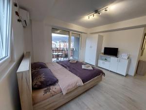 - une chambre avec un grand lit et un balcon dans l'établissement Dzusy Apartments, à Ohrid