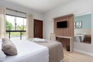une chambre d'hôtel avec un lit et une télévision dans l'établissement Pousada Salto Donner, à Rio Forcação