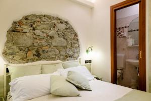 a bedroom with a stone wall and a bed with pillows at Hotel Marina in Monterosso al Mare