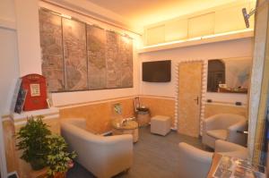 a living room with chairs and a tv and a room at Hotel Marina in Monterosso al Mare