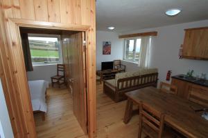 a kitchen and living room with a table and a couch at Casa Branca do Porto in Cinco Ribeiras