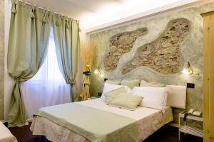 a bedroom with a large bed with a stone wall at Hotel Marina in Monterosso al Mare
