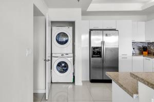 een keuken met een wasmachine en droger naast een koelkast bij Perfect condo, room for everyone! Beachfront resort in South Padre Island