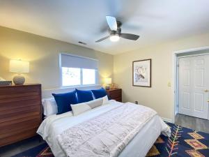 New! 2BR Ski in n out Mtn. Creek في Vernon Township: غرفة نوم مع سرير مع وسائد زرقاء ومروحة سقف