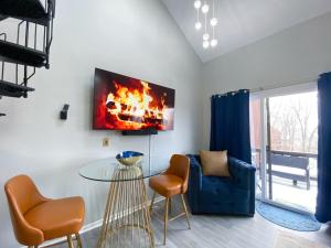 a living room with a table and a fire on the wall at New! 2BR Ski in n out Mtn. Creek in Vernon Township