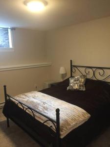 a bedroom with a black bed with a pillow at Cozy 1-bedroom in Bauer Terrace next to Citadel in Halifax