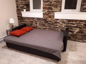 1 cama con 2 almohadas rojas en una habitación en Cozy 1-bedroom in Bauer Terrace next to Citadel, en Halifax