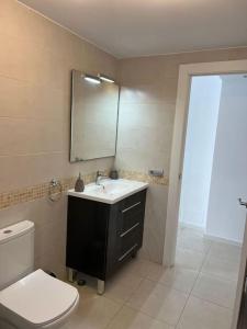ein Badezimmer mit einem WC, einem Waschbecken und einem Spiegel in der Unterkunft Parque Royal Costa Adeje in Adeje