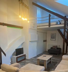 uma sala de estar com um loft com um sofá e uma mesa em Bella Penzion em Komárno