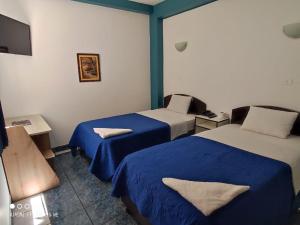 a hotel room with two beds and a television at Zentrico Hotel in Chiclayo