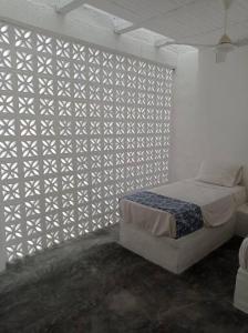 a bedroom with a bed and a white wall at Casa de Recreo - Vacation House in Honda