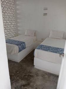 two beds in a room with white walls at Casa de Recreo - Vacation House in Honda
