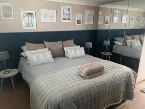 a bedroom with a bed with a blanket and mirrors at Forever Summer in Lymington